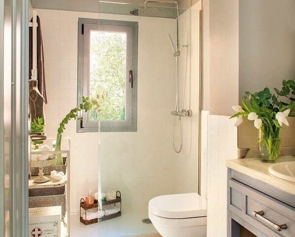 Phòng tắm hiện đại với cửa sổ, vòi sen, bồn rửa, gương và cây xanh tạo không gian thoáng đãng.