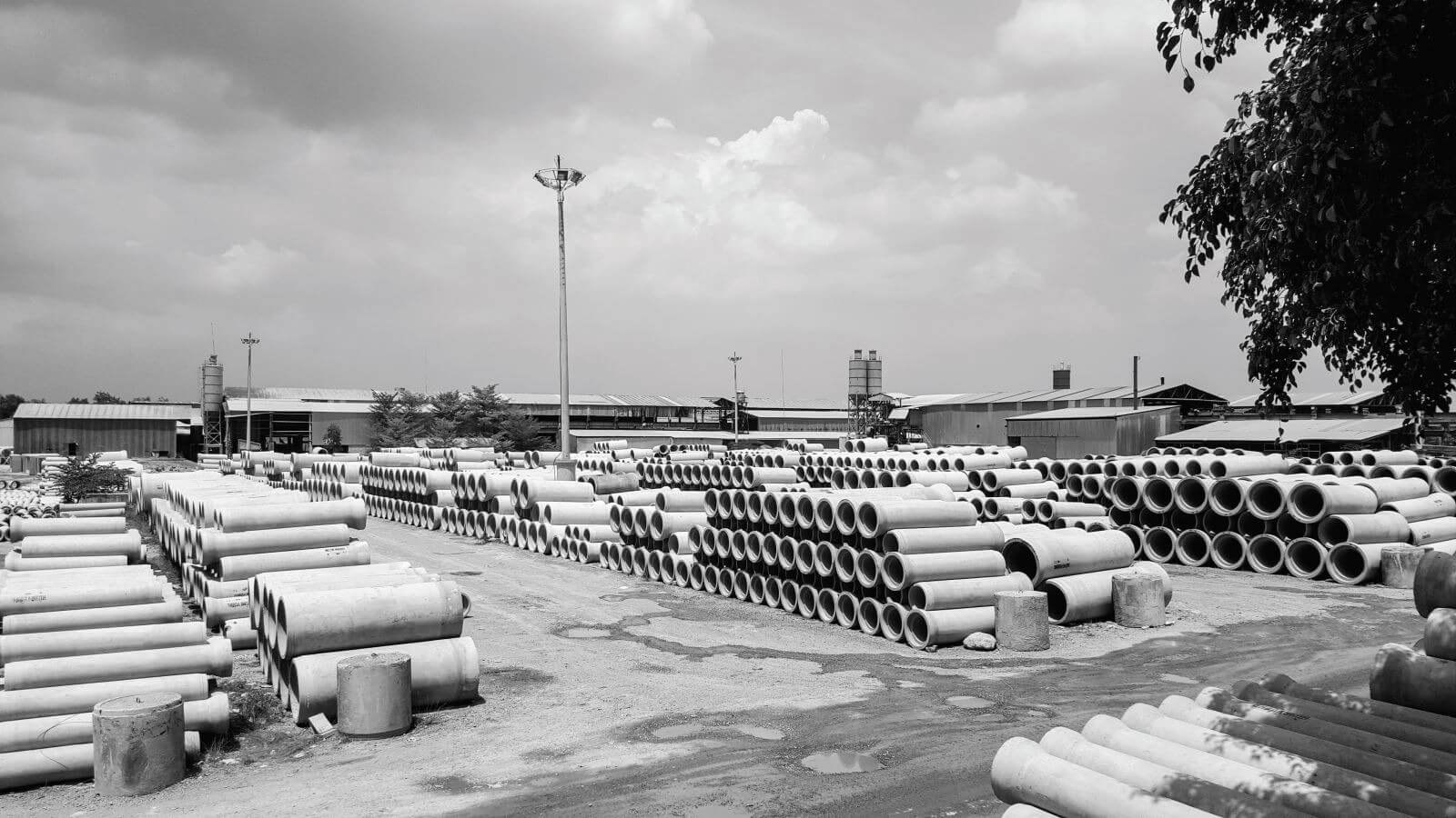 lr4hdz81veswo3b6p0nt Kho ống bê tông lớn ngoài trời tại một khu công nghiệp. Các ống được xếp thành hàng ngăn nắp.