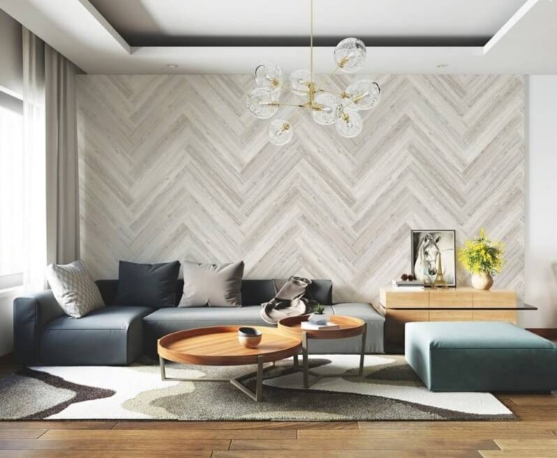 lua-chon-giay-dan-tuong-phong-khach-2 Phòng khách hiện đại với ghế sofa xanh, bàn tròn gỗ, đèn trần phong cách và tường họa tiết xương cá.