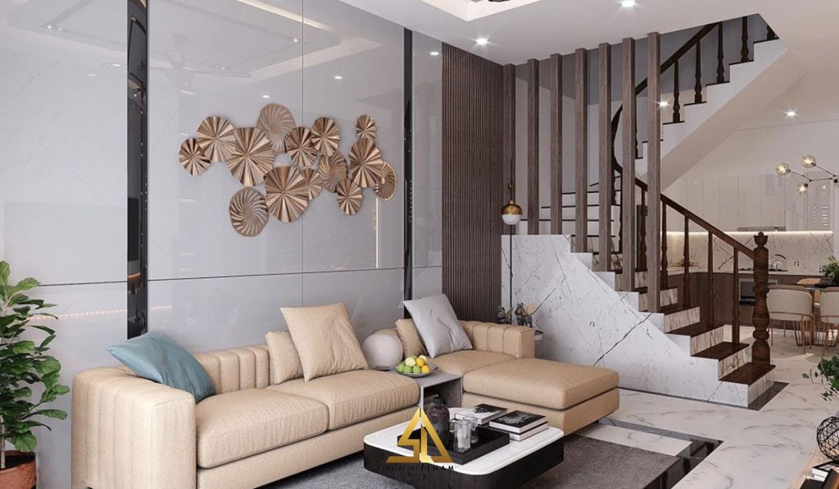 Phòng khách hiện đại với sofa màu kem, cầu thang gỗ, và trang trí tường nghệ thuật độc đáo.
