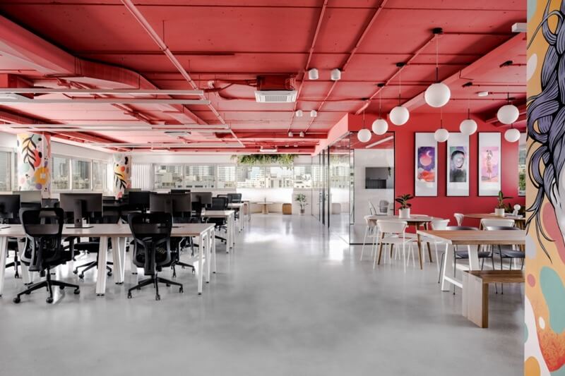 Văn phòng hiện đại với trần đỏ, bàn làm việc và khu vực nghỉ ngơi thoáng đãng.
