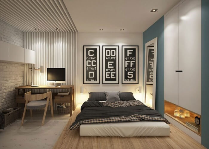 luu-y-khi-thiet-ke-phong-ngu-3x5m-1 Phòng ngủ hiện đại với giường, bàn làm việc, và tranh treo tường, ánh sáng ấm áp.