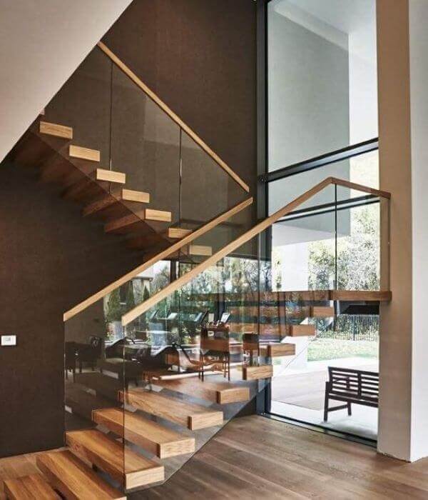 Cầu thang gỗ hiện đại với lan can kính trong suốt, nội thất sang trọng trong môi trường sáng sủa.
