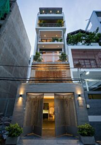 Nhà phố hiện đại 4 tầng, kiến trúc tối giản với cửa sổ và ban công rộng rãi, ánh sáng ban đêm lung linh.