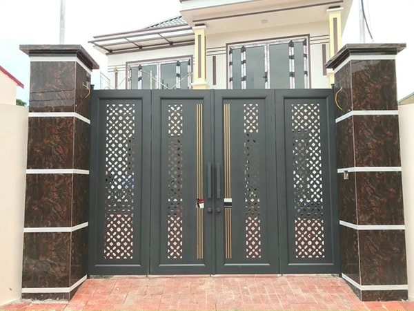 Cổng sắt hiện đại màu đen với thiết kế họa tiết hoa văn đối xứng, lối vào ngôi nhà hai tầng sang trọng.