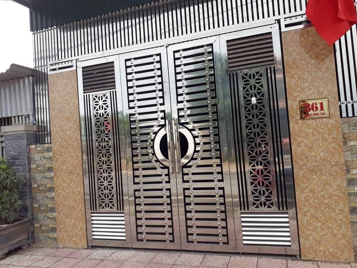 mau-cong-inox-2-canh-3 Cổng inox hiện đại với hoa văn hình học, số nhà 361, nền đá cẩm thạch, quốc kỳ đỏ bên phải.