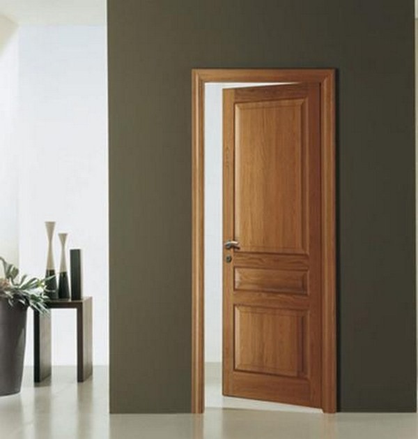 Cửa gỗ màu nâu mở một góc, bên cạnh bàn trang trí hiện đại, tường màu tối.