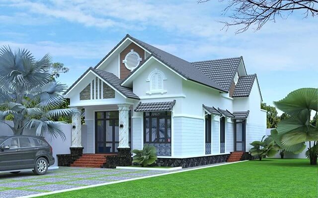 Nhà cấp 4 mái thái hiện đại màu trắng, sân vườn rộng, cây cối xanh tươi, ô tô đỗ trước nhà.