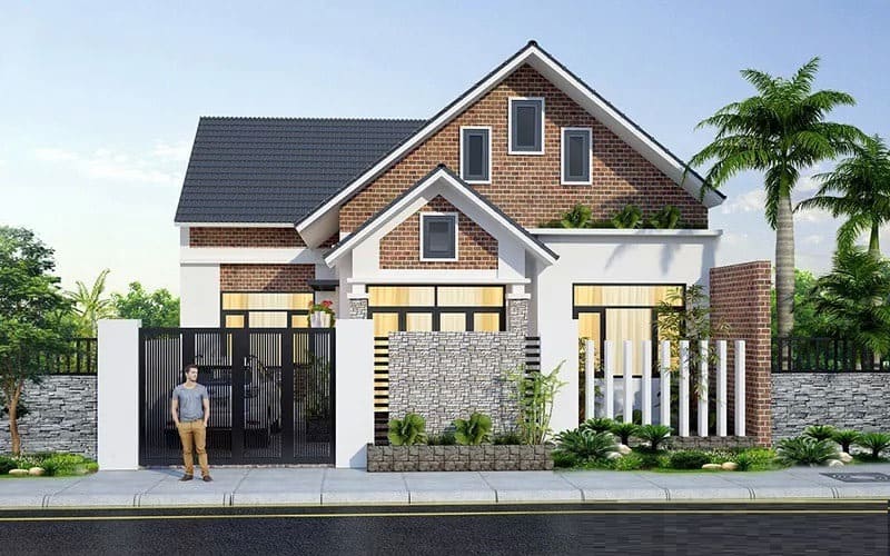 Nhà kiểu hiện đại hai tầng với mái ngói xám, trang trí với cây xanh, mặt tiền lát gạch, người đứng trước cổng.