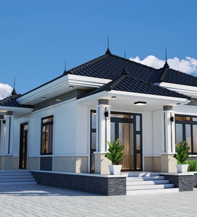 Nhà cấp 4 kiểu mái Thái hiện đại với sân lát gạch và cây xanh, trời xanh quang đãng.