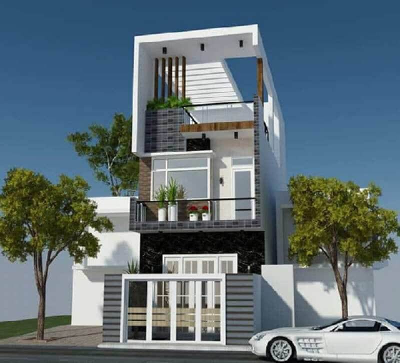 Nhà phố hiện đại ba tầng với cửa sổ lớn và cây xanh xung quanh, bên cạnh là ô tô trắng.