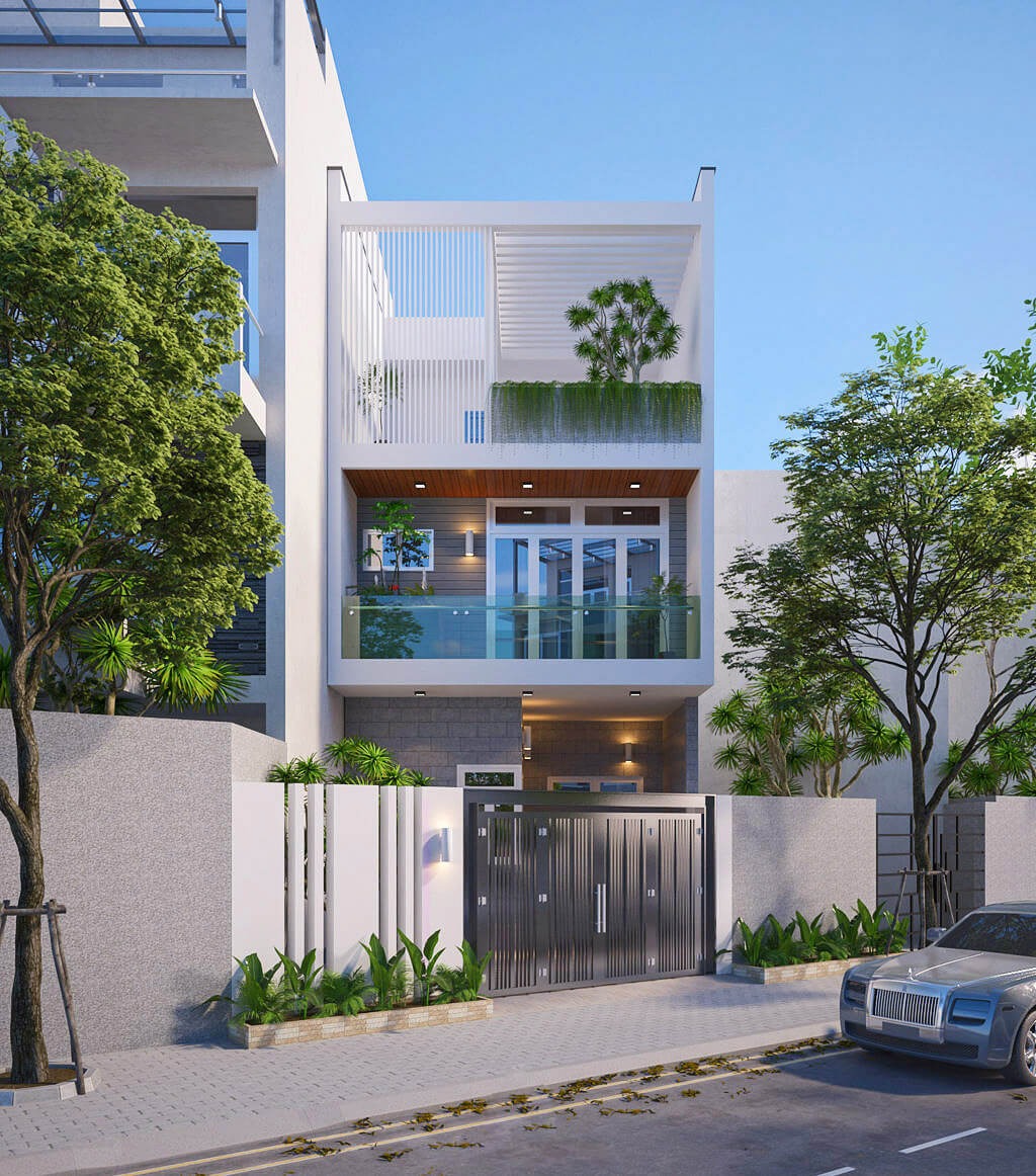 Mặt tiền nhà hiện đại, ba tầng, có cổng lớn, ban công kính và cây xanh xung quanh.