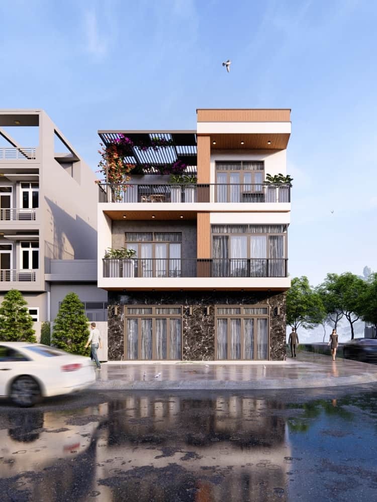 Nhà phố hiện đại ba tầng với ban công cây xanh và cửa kính lớn, xe di chuyển trên đường phía trước.