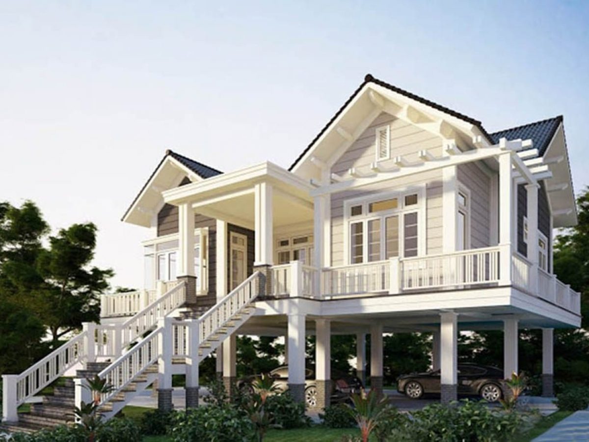 Nhà sàn hiện đại hai tầng với mái ngói, cửa kính lớn, sân vườn xanh mát, phong cách thiết kế tinh tế.