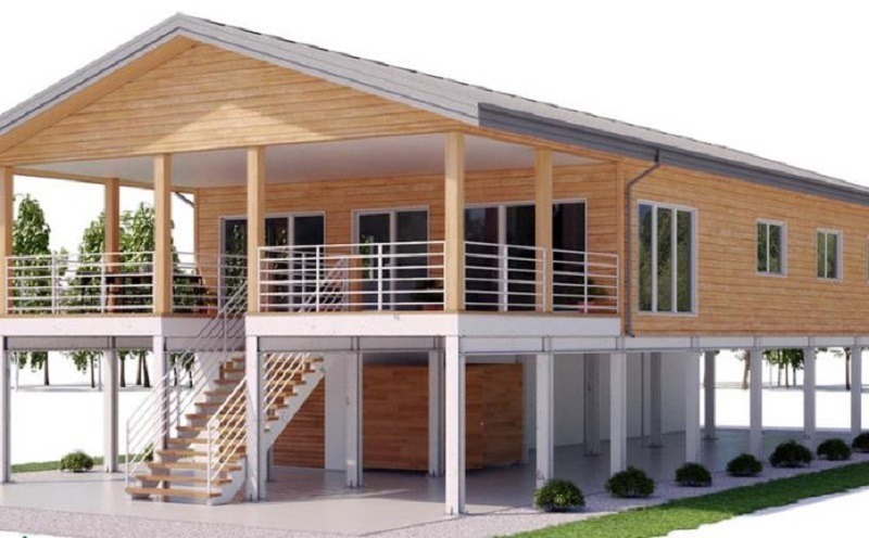 Nhà sàn gỗ hai tầng hiện đại với lan can trắng và cây xanh xung quanh.