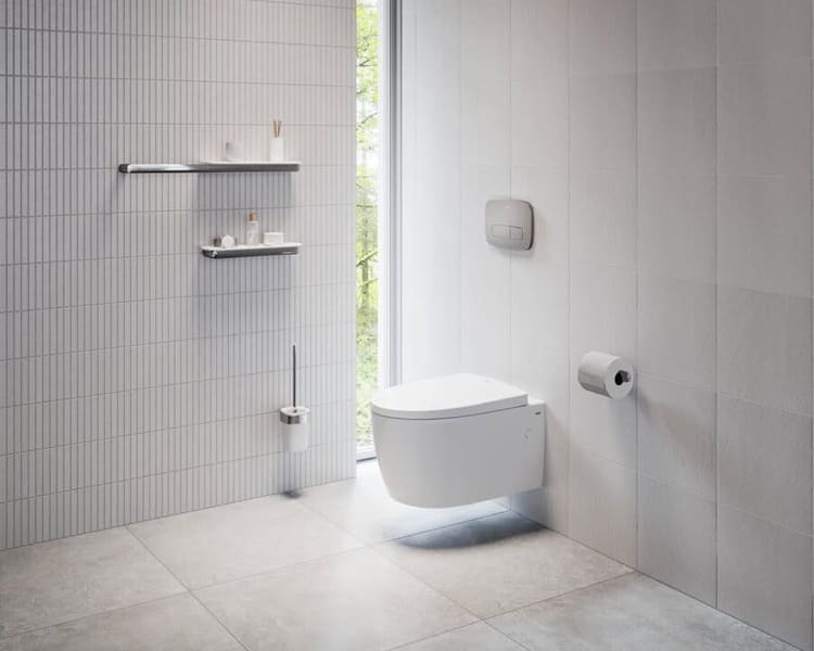 Phòng tắm hiện đại với toilet treo tường, gạch sáng và kệ đựng đồ, ánh sáng tự nhiên qua cửa kính.