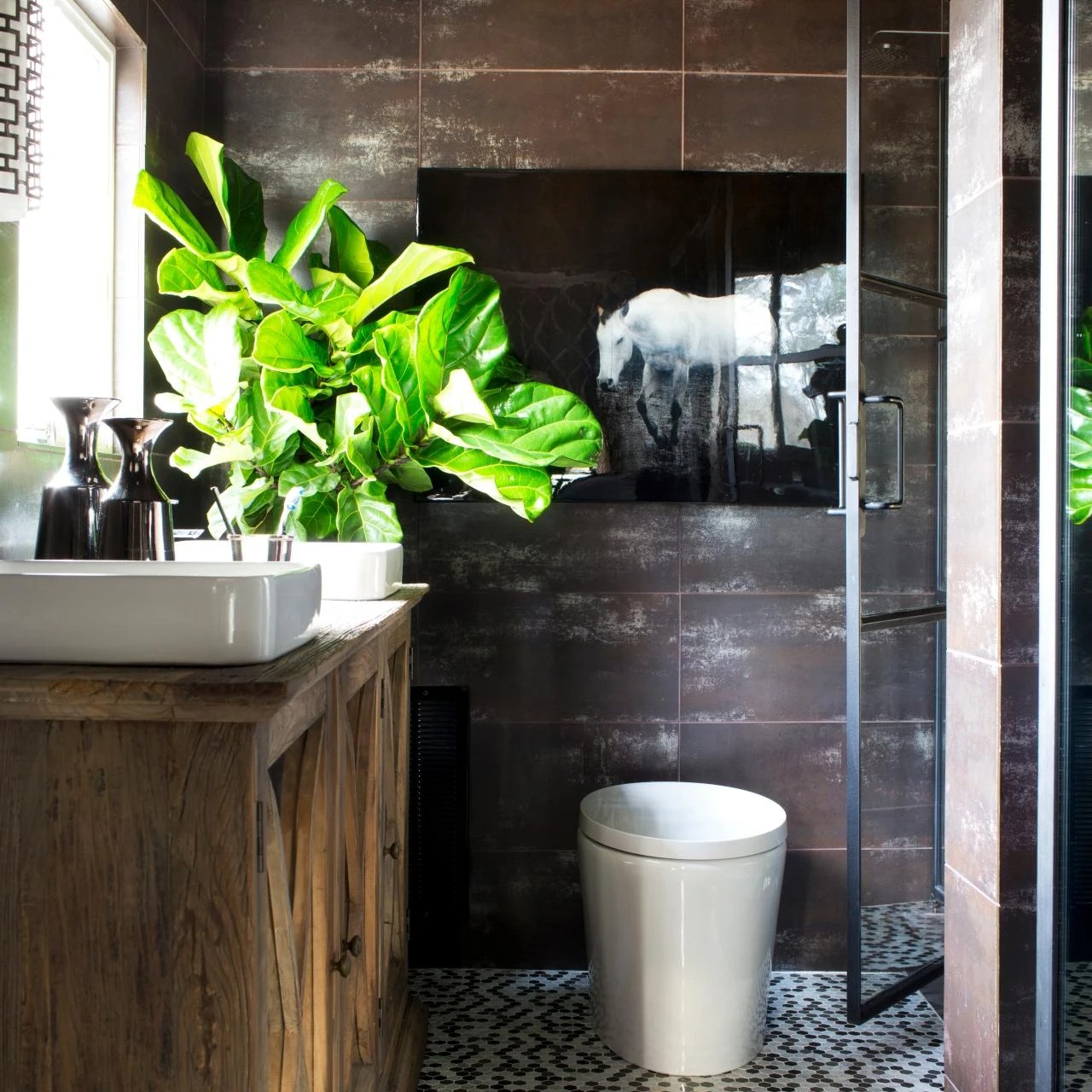 Phòng tắm hiện đại với bồn rửa, cây xanh lớn và tranh ngựa trắng treo tường tạo không gian thư giãn.