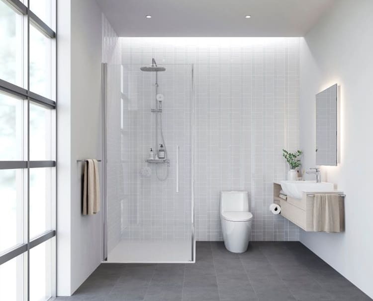 Phòng tắm hiện đại với vòi sen, bồn cầu và bồn rửa, tông màu trắng và xám, ánh sáng tự nhiên qua cửa sổ kính.