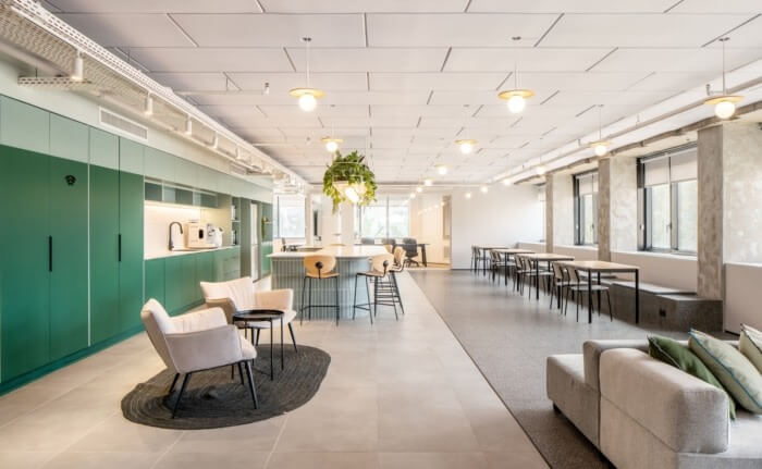 Văn phòng hiện đại với nội thất sang trọng, thiết kế mở, bàn ghế, sofa thoải mái và cây xanh trang trí.