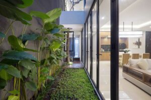 Nội thất hiện đại với vườn cây xanh mát bên cửa sổ kính, tạo cảm giác gần gũi với thiên nhiên.