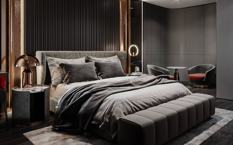 Phòng ngủ hiện đại với giường lớn, đèn bàn đồng, và ghế thư giãn phong cách sang trọng.