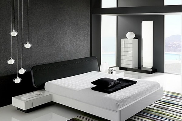 Phòng ngủ hiện đại với tường đen, giường trắng và đèn trang trí. Nội thất tối giản và cửa sổ lớn, ánh sáng tự nhiên.