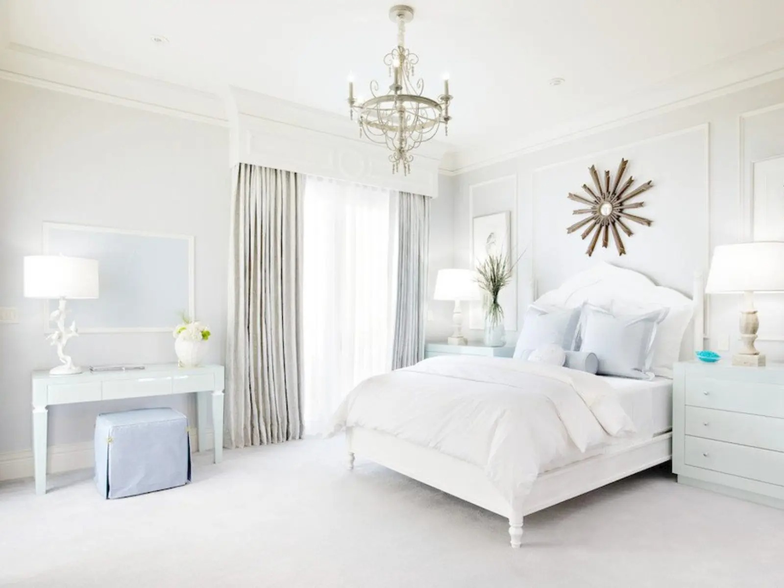 Phòng ngủ hiện đại với nội thất trắng, đèn chùm tinh tế, và phong cách trang trí tối giản.