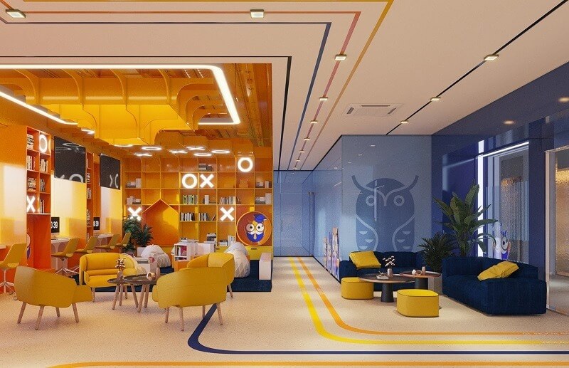 Không gian văn phòng hiện đại với nội thất màu vàng và xanh, trang trí sáng tạo với ghế sofa và cây xanh.