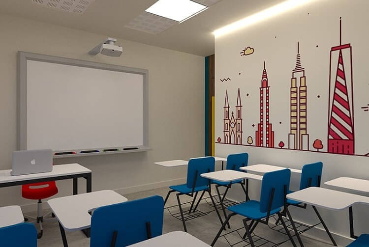 Phòng học hiện đại với bàn ghế xanh, bảng trắng, tranh tường họa tiết tòa nhà nổi bật.