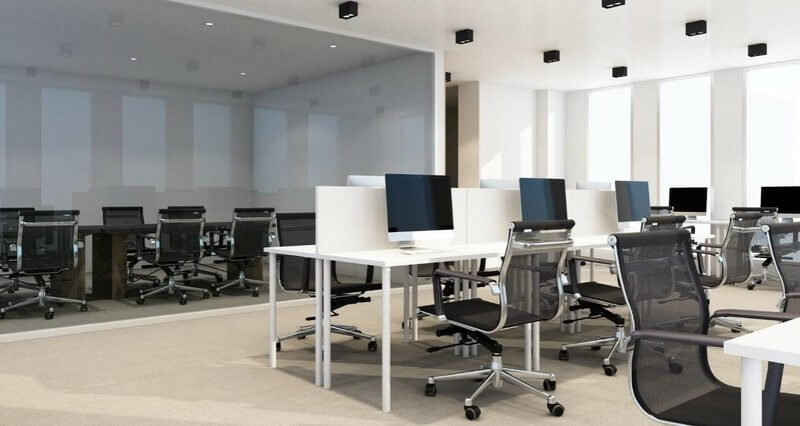 Văn phòng hiện đại với bàn trắng, ghế xoay và máy tính, ánh sáng tự nhiên qua cửa sổ lớn.