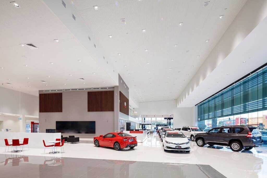 Phòng trưng bày xe hơi sang trọng với nhiều mẫu ô tô hiện đại và ánh sáng tự nhiên.