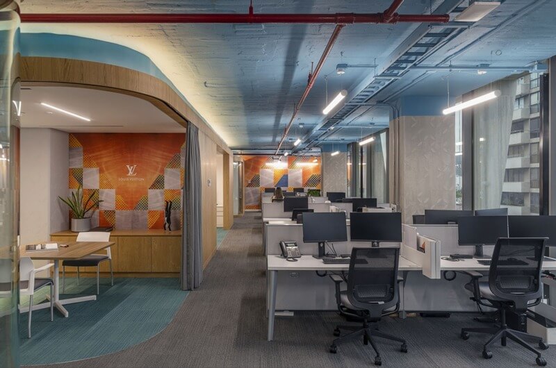 Văn phòng hiện đại với bàn làm việc, máy tính và trang trí nội thất sang trọng.