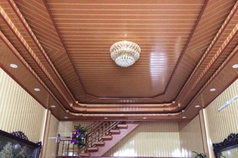 Trần nhà bằng gỗ với đèn chùm sang trọng trong phòng khách, nội thất gỗ ấm cúng và cầu thang tinh tế.