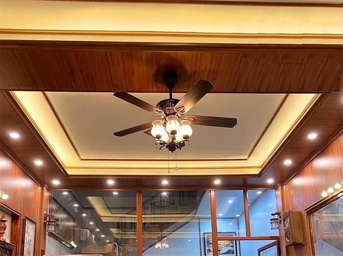 Quạt trần đèn trang trí trong phòng khách sang trọng với đèn LED và trần gỗ hiện đại.