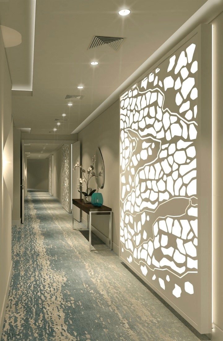 Hành lang có thảm xanh, đèn trần hiện đại và tường trang trí hoa văn nổi bật.