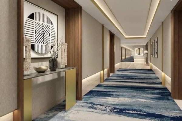 Hành lang khách sạn sang trọng với thảm xanh và tường gỗ hiện đại, trang trí nghệ thuật tối giản.