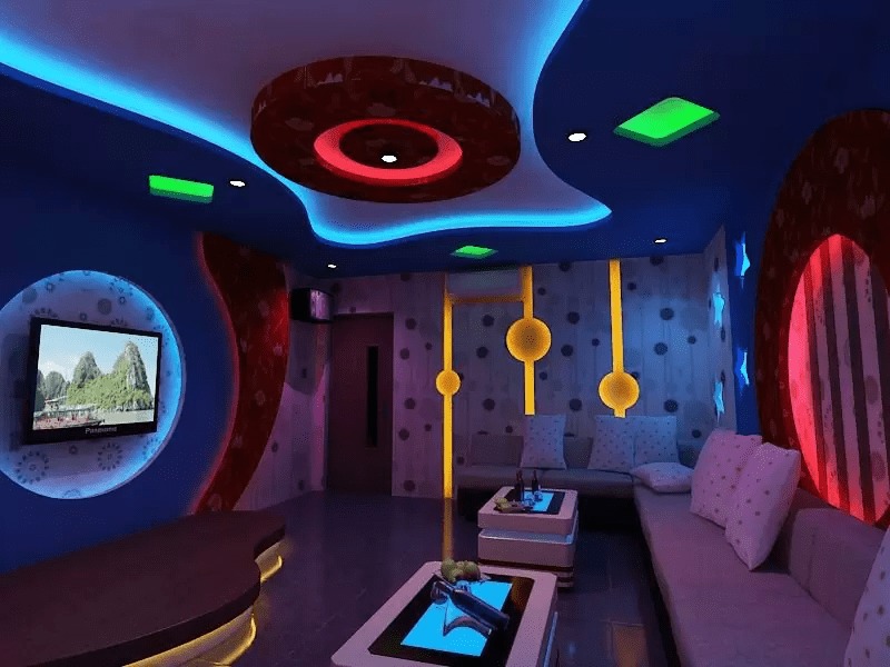 mot-so-luu-y-khi-thi-cong-vach-va-tran-thach-cao-cho-phong-karaoke Phòng karaoke hiện đại với ánh sáng neon rực rỡ và màn hình TV lớn trên tường.