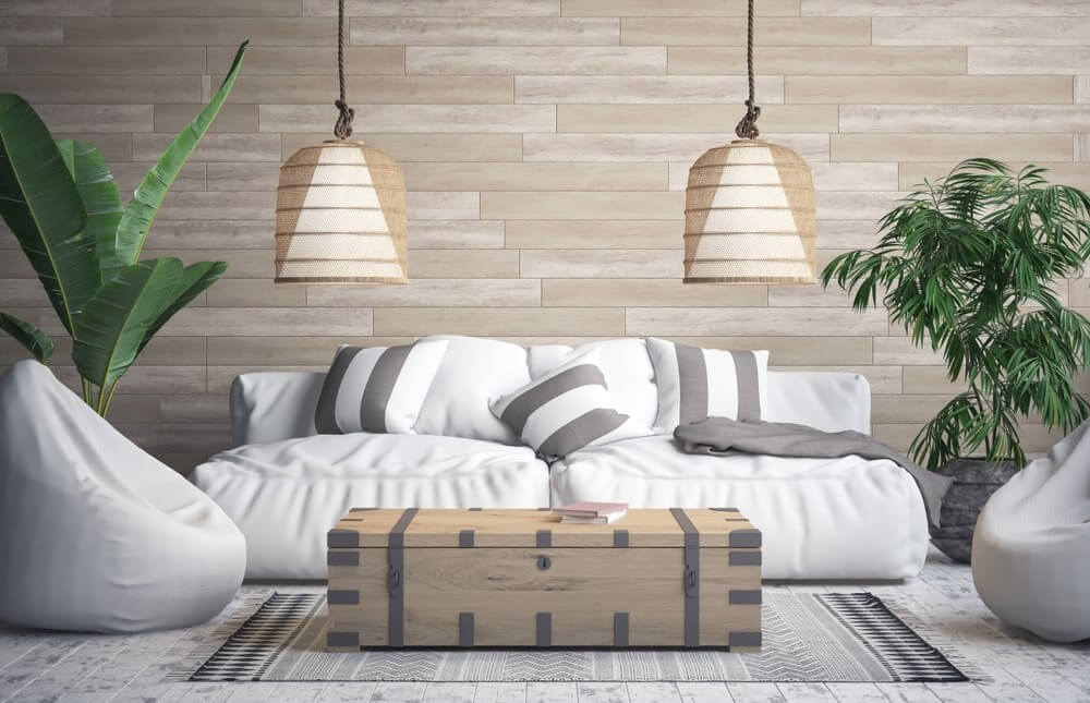 Phòng khách hiện đại với ghế sofa trắng, đèn treo và cây xanh. Nội thất trang nhã tạo không gian thoải mái.