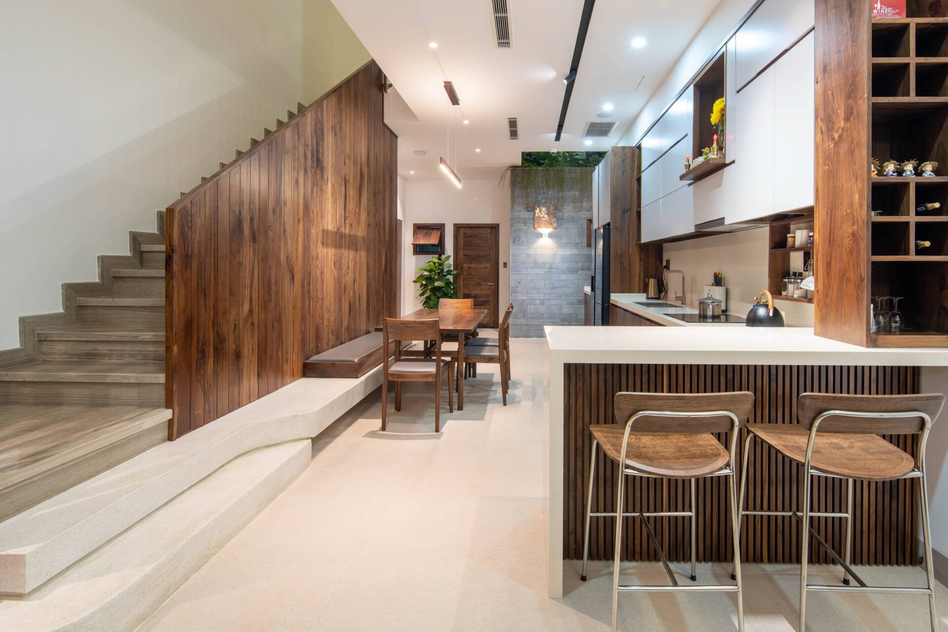 nguyen-tac-khi-thiet-ke-cau-thang-doc-3 Phòng bếp hiện đại với thiết kế gỗ, bàn ăn gỗ và ánh sáng tự nhiên.