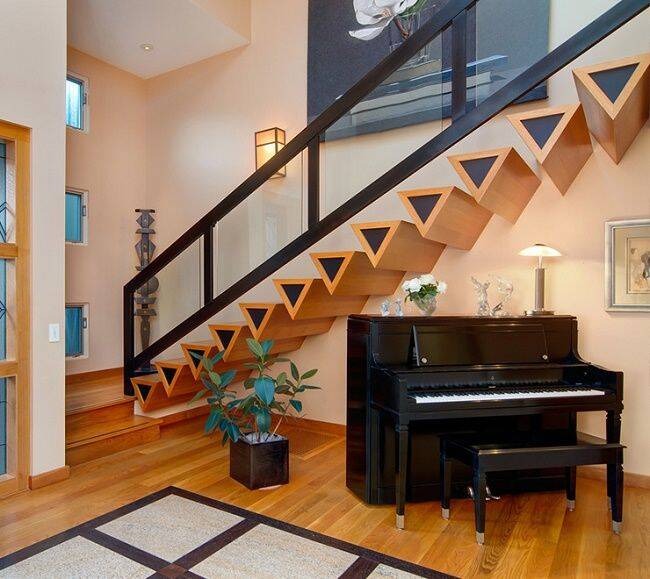 nguyen-tac-khi-thiet-ke-cau-thang-doc-4 Cầu thang gỗ sáng tạo thiết kế hình tam giác, bên dưới là đàn piano đen và cây xanh, nội thất hiện đại.