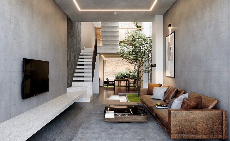 Phòng khách hiện đại với sofa da, cây xanh và cầu thang nổi bật trong không gian mở phong cách tối giản.