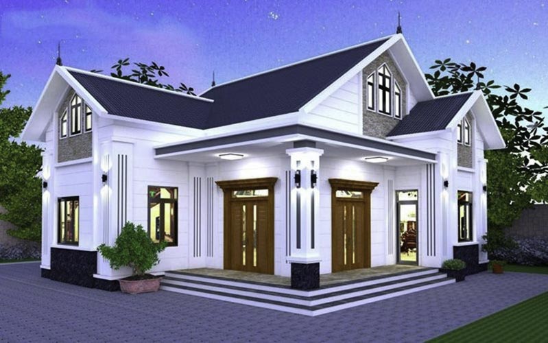 Ngôi nhà hai tầng hiện đại, mái ngói xanh, ánh sáng ban đêm, có cây xanh phía trước, kiến trúc sang trọng và cuốn hút.