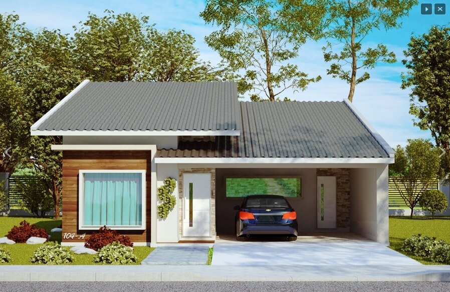 Nhà cấp 4 hiện đại với mái ngói xám, cửa kính lớn và gara ô tô, xung quanh là cây xanh và cảnh quan.