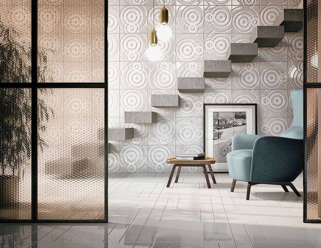 Không gian nội thất hiện đại với ghế bành, cầu thang nổi và tường trang trí họa tiết hình tròn.