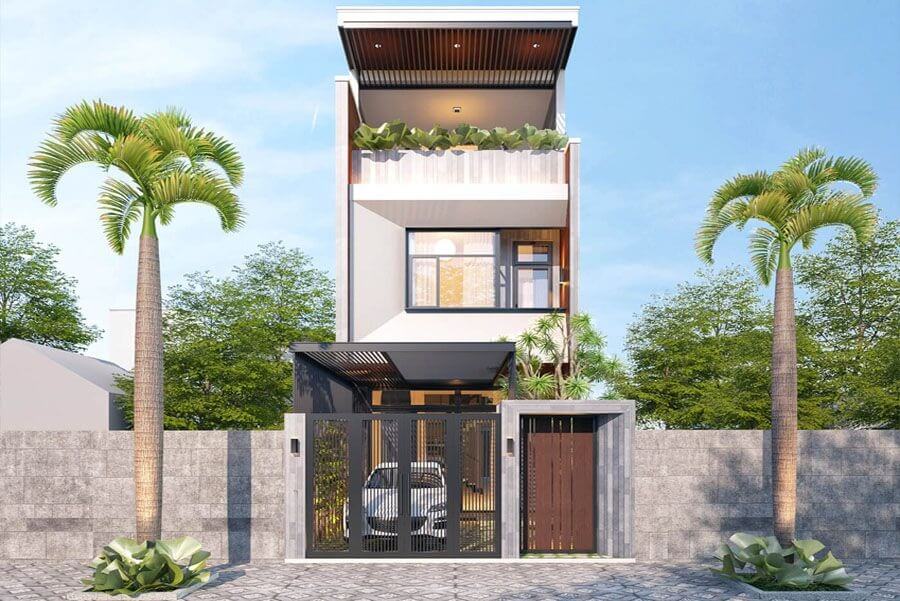 Nhà phố 3 tầng hiện đại với cây xanh hai bên, tường rào đá, cửa sổ kính, và gara ô tô, bầu trời xanh.