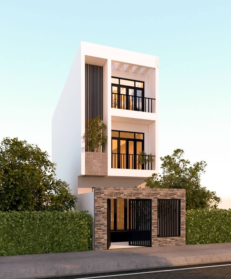 Nhà phố hiện đại ba tầng với cửa kính lớn, ban công, cổng đá và hàng rào cây xanh, ánh sáng tự nhiên.
