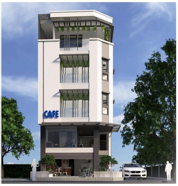 Tòa nhà cao tầng hiện đại với quán cà phê nhỏ ở tầng trệt, cây xanh xung quanh và ô tô đậu phía trước.