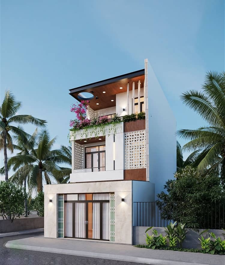 Ngôi nhà hiện đại ba tầng với ban công trồng nhiều cây xanh và hoa, xung quanh có cây cọ và bầu trời trong xanh.