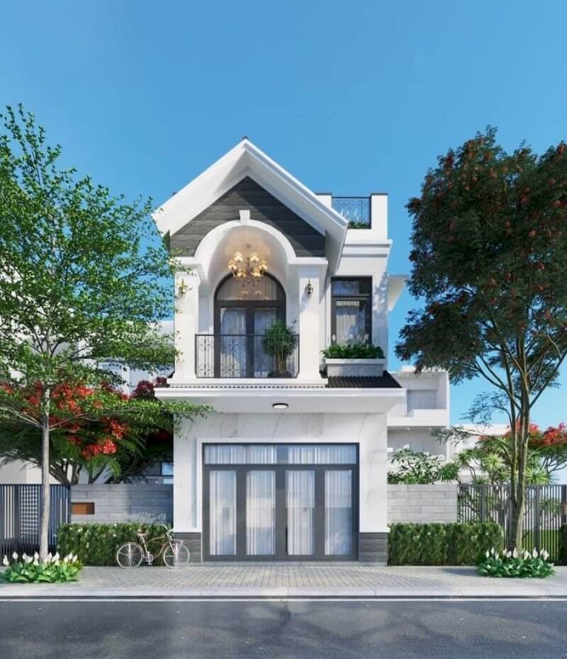 Nhà hai tầng hiện đại với mặt tiền sang trọng, cửa kính lớn, cây cối xanh tươi và bầu trời trong xanh.