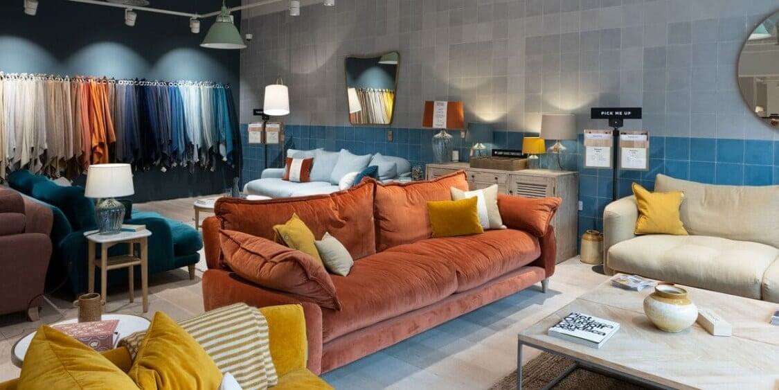 Phòng trưng bày nội thất hiện đại với ghế sofa đa sắc và vải dệt treo màu sắc khác nhau.